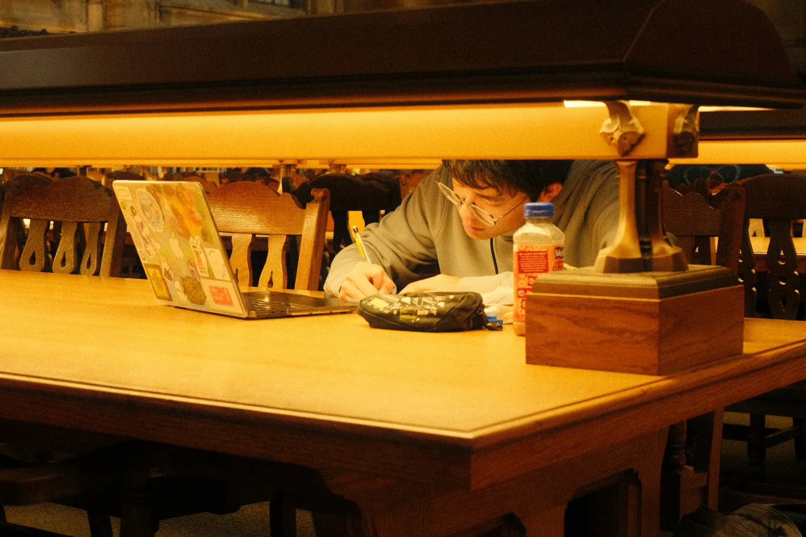 A learner studying independently at a library desk